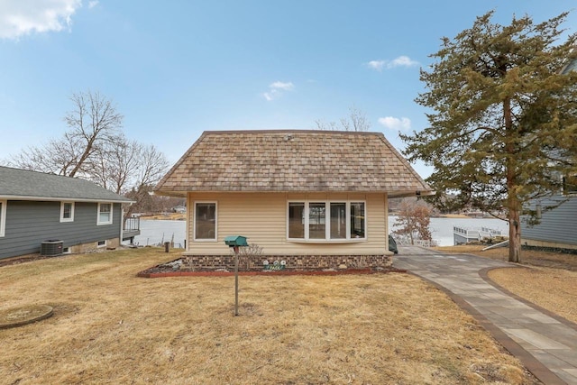 back of house with a shingled roof, a yard, and central AC unit