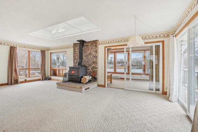 interior space featuring carpet floors, a baseboard radiator, a wood stove, and baseboards