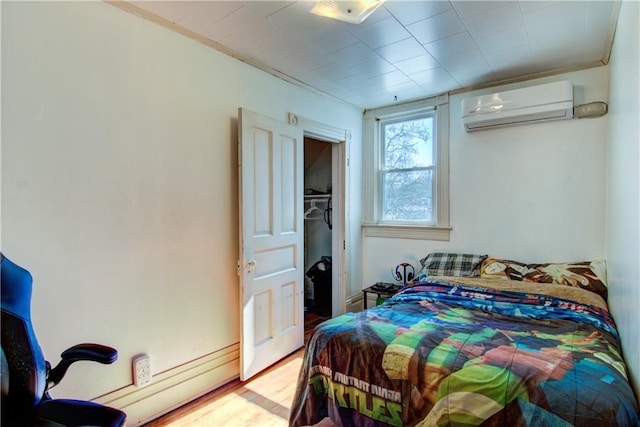 bedroom featuring an AC wall unit and wood finished floors