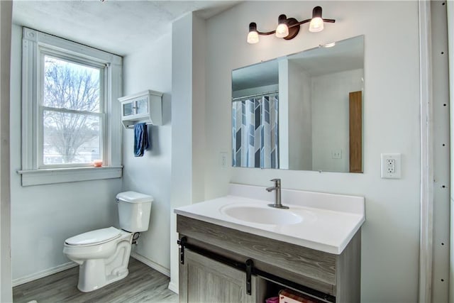 full bathroom with wood finished floors, vanity, toilet, and baseboards