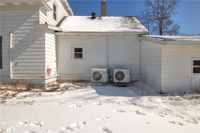 snow covered property featuring ac unit