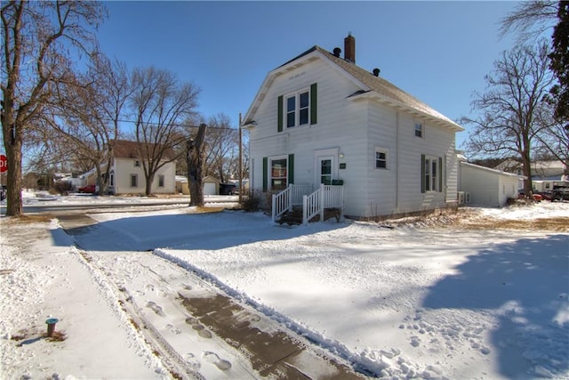 view of snowy exterior featuring a chimney