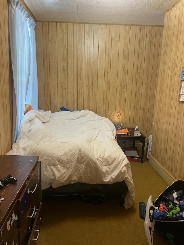 carpeted bedroom with wooden walls