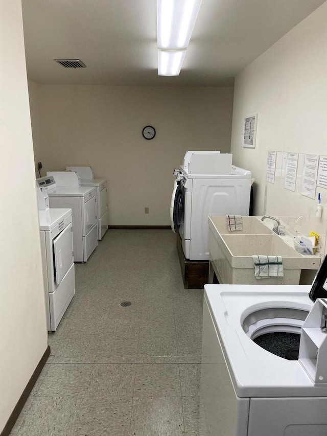 community laundry room with baseboards, visible vents, a sink, and independent washer and dryer