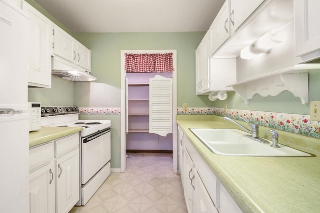 kitchen with a sink, under cabinet range hood, light countertops, and white range with electric cooktop