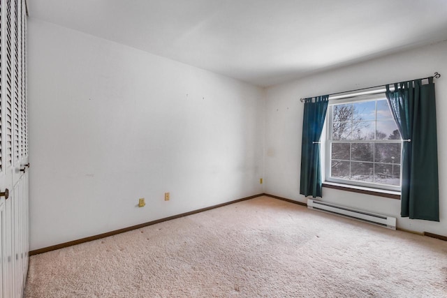 unfurnished room featuring carpet, a baseboard heating unit, and baseboards