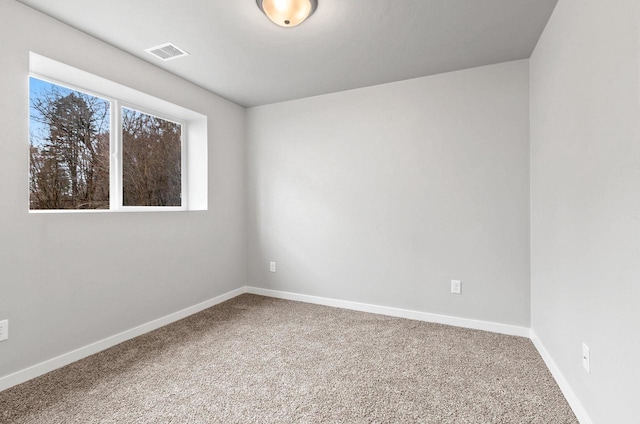 carpeted empty room with visible vents and baseboards