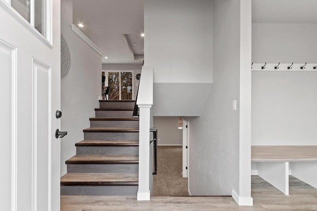 stairs with recessed lighting, wood finished floors, and baseboards