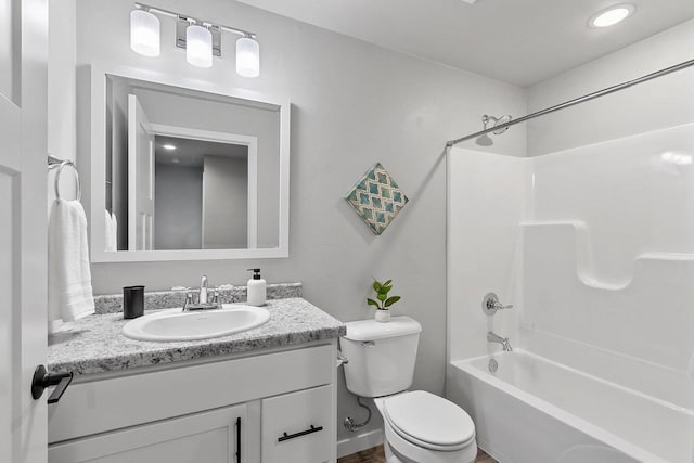 full bathroom featuring tub / shower combination, vanity, and toilet