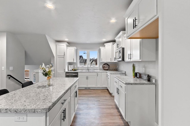 kitchen with appliances with stainless steel finishes, a sink, light wood-style flooring, and recessed lighting