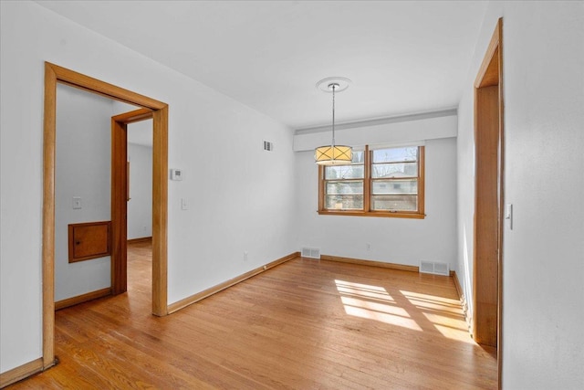 unfurnished dining area with visible vents, light wood-style flooring, and baseboards