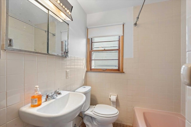 full bathroom with shower / tub combination, toilet, tile walls, and a sink