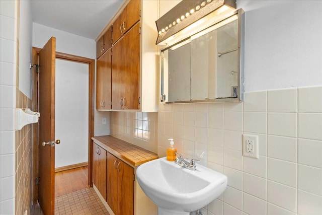 bathroom with a sink and tile walls