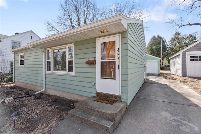 view of front facade featuring entry steps, an outbuilding, and a detached garage