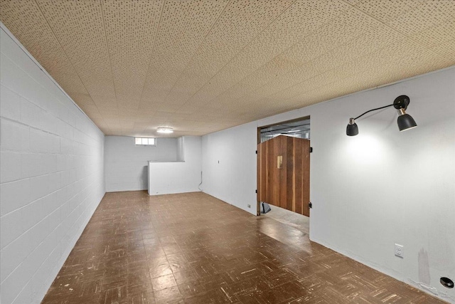 basement featuring tile patterned floors and concrete block wall