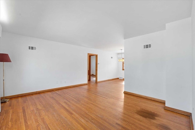 empty room with visible vents, baseboards, and light wood-style floors