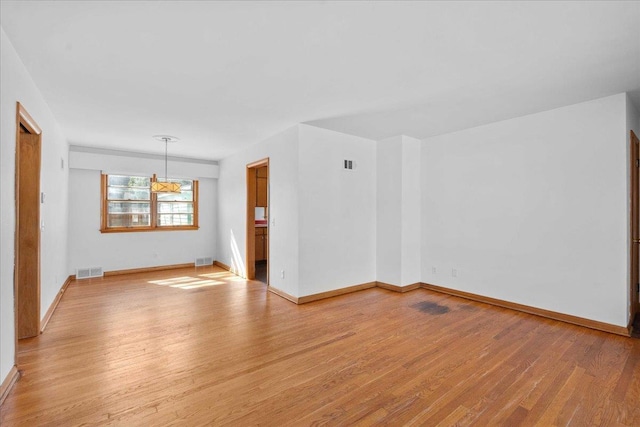 spare room with visible vents, baseboards, and light wood-style flooring