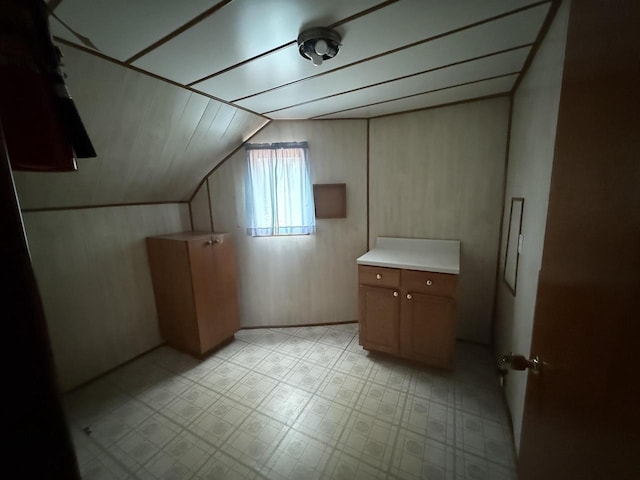 bonus room with vaulted ceiling and light floors