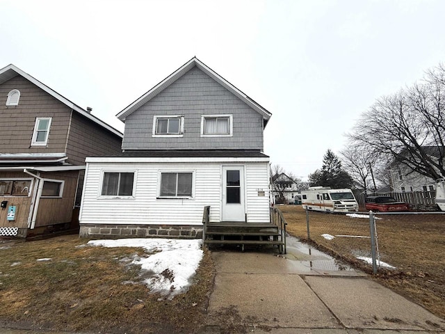 back of property with entry steps and fence