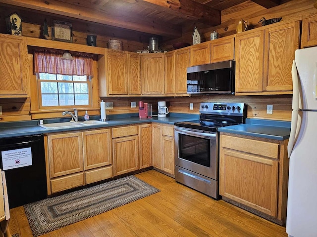 kitchen with beam ceiling, stainless steel electric range oven, freestanding refrigerator, a sink, and dishwasher