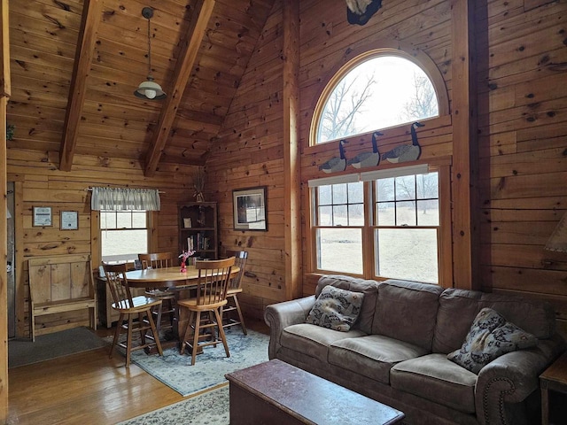 living room with wood ceiling, wood finished floors, wood walls, high vaulted ceiling, and beam ceiling