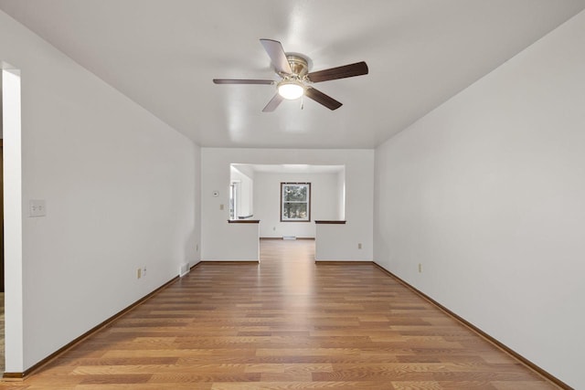 unfurnished room featuring light wood-style floors, ceiling fan, and baseboards