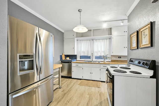 kitchen featuring crown molding, appliances with stainless steel finishes, light wood-style floors, white cabinets, and a sink