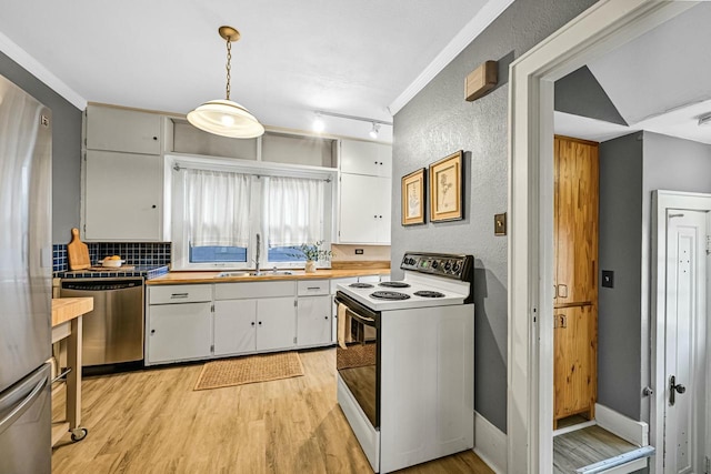 kitchen with light wood-style flooring, a sink, stainless steel appliances, white cabinets, and a textured wall