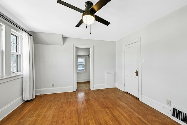 unfurnished bedroom with ceiling fan, visible vents, baseboards, and wood finished floors