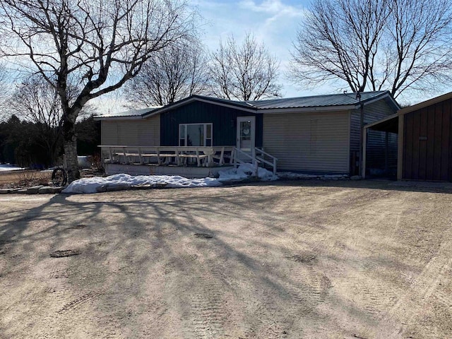 view of front of house with driveway and metal roof