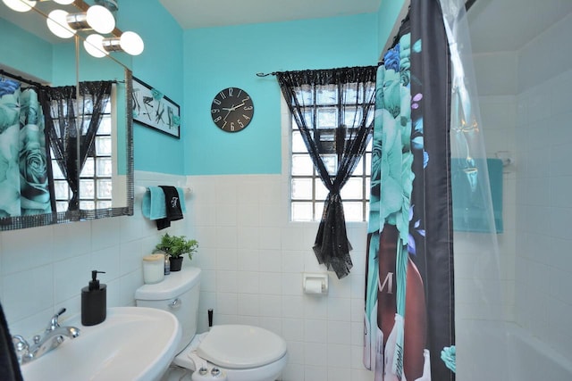 full bath featuring a healthy amount of sunlight, tile walls, toilet, and a sink