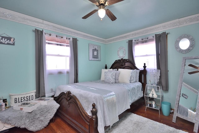 bedroom featuring a ceiling fan, crown molding, and wood finished floors