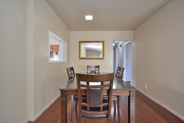 dining space featuring baseboards and dark wood-style flooring