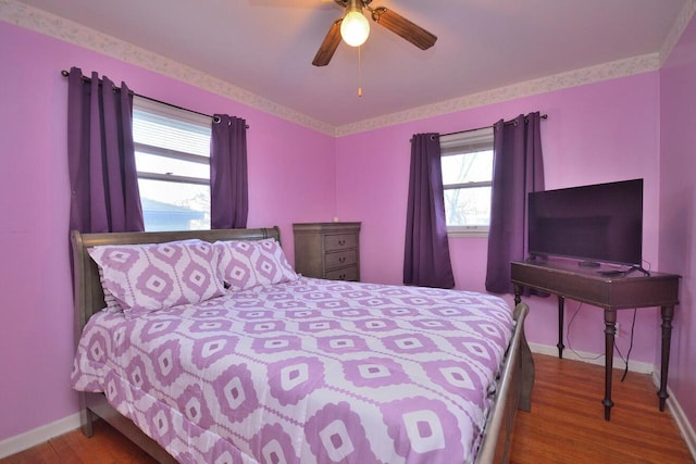 bedroom with wood finished floors, a ceiling fan, and baseboards