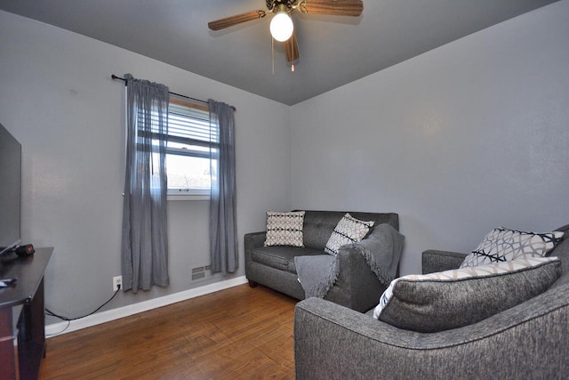 living room featuring visible vents, ceiling fan, baseboards, and wood finished floors