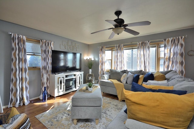 living area featuring ceiling fan, wood finished floors, and baseboards