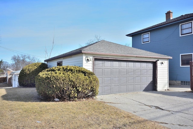 view of side of home featuring roof with shingles, a lawn, and an attached garage