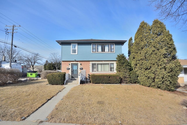 view of front of home featuring brick siding and a front yard