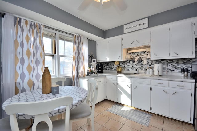 kitchen with light tile patterned floors, ceiling fan, decorative backsplash, and a sink