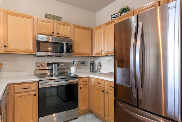 kitchen with appliances with stainless steel finishes, light countertops, and light brown cabinets