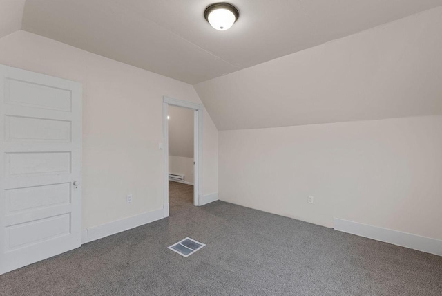 additional living space with a baseboard radiator, visible vents, dark carpet, and lofted ceiling