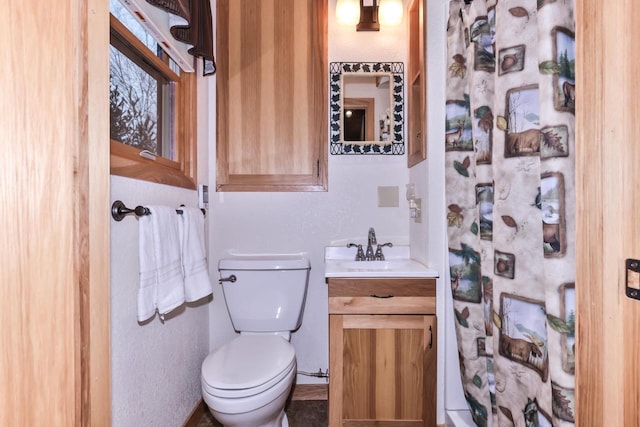 full bath with a shower with curtain, vanity, and toilet