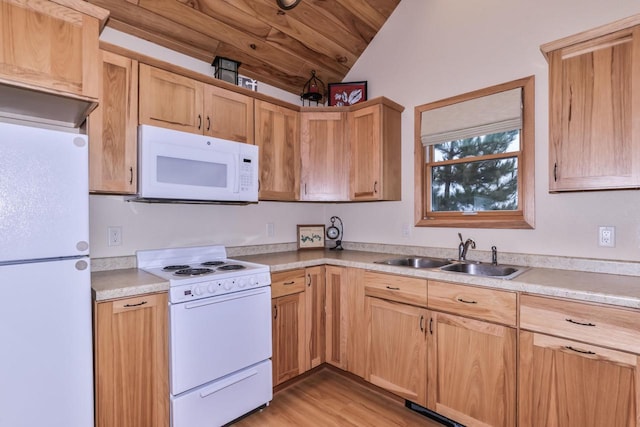 kitchen with lofted ceiling, light countertops, white appliances, and a sink