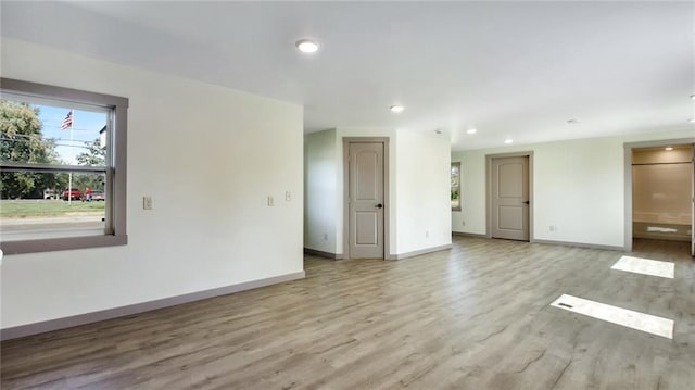 empty room with recessed lighting, wood finished floors, and baseboards