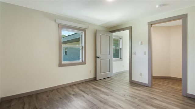 unfurnished bedroom featuring light wood-type flooring and baseboards