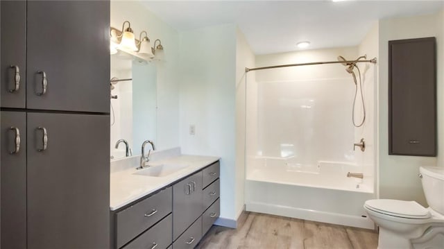 bathroom featuring vanity, shower / tub combination, wood finished floors, and toilet