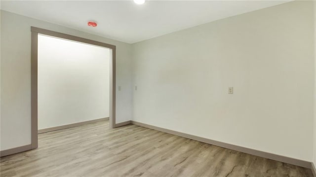 unfurnished room with light wood-style flooring and baseboards