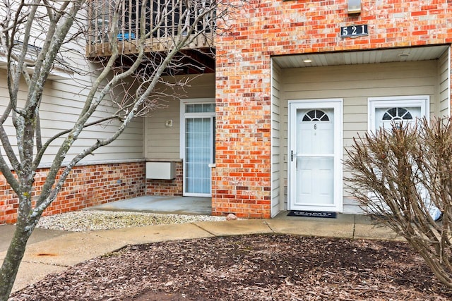 view of exterior entry featuring brick siding