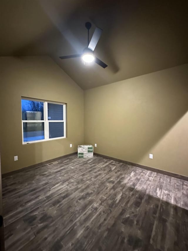 additional living space with dark wood-style floors, lofted ceiling, ceiling fan, and baseboards