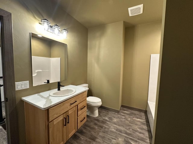 full bathroom featuring toilet, wood finished floors, vanity, visible vents, and baseboards